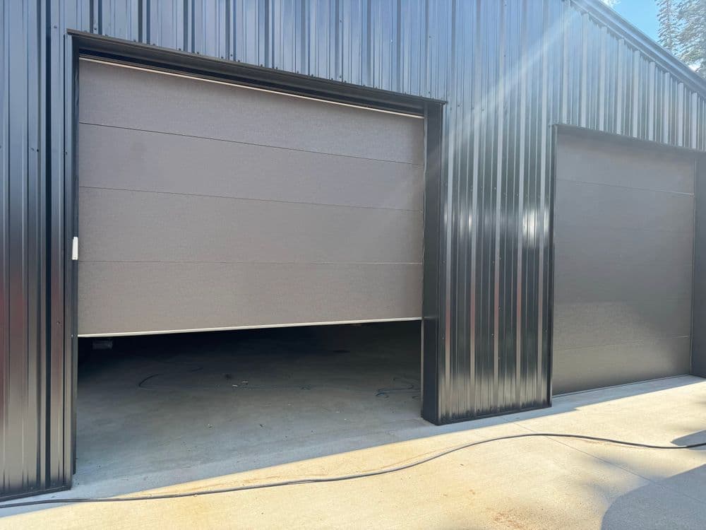 Modern metal garage with two closed sectional doors, featuring a sleek gray finish.