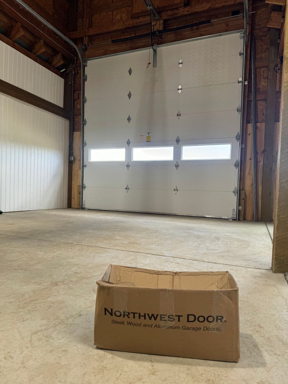 Garage interior with a Northwest Door box and large white roll-up garage door.